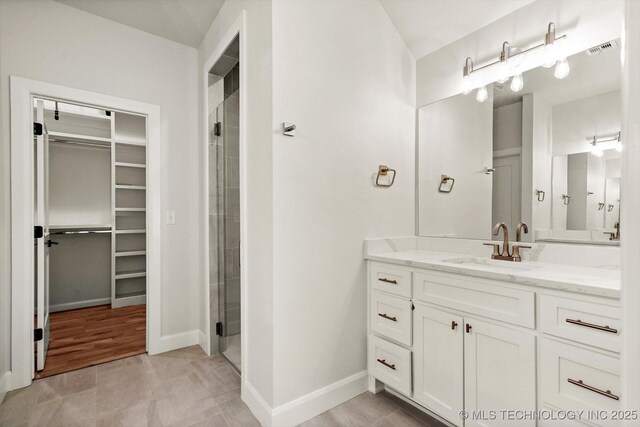 13236 E 4th Pl, Tulsa, OK 74108 - bathroom featuring a walk in closet, vanity, and a shower stall