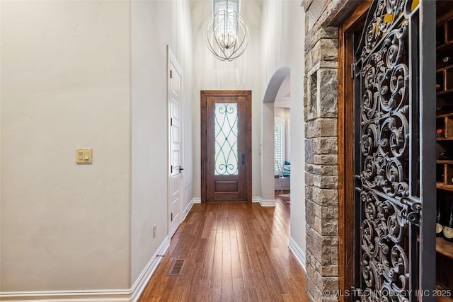 1536 E 35th Pl, Tulsa, OK 74105 - foyer featuring arched walkways, hardwood / wood-style flooring, and a chandelier