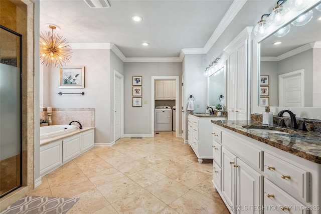 1536 E 35th Pl, Tulsa, OK 74105 - bathroom with washer / clothes dryer, a stall shower, a garden tub, recessed lighting, and two vanities