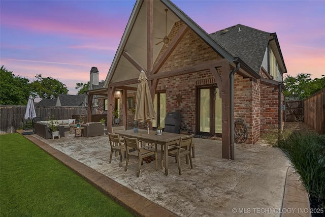 1536 E 35th Pl, Tulsa, OK 74105 - back of house featuring outdoor lounge area, a patio area, a fenced backyard, brick siding, and a shingled roof