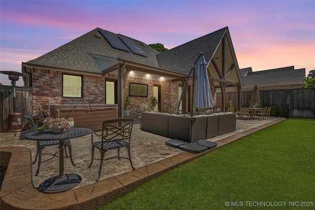 1536 E 35th Pl, Tulsa, OK 74105 - back of property with a hot tub, a shingled roof, a patio, roof mounted solar panels, and outdoor lounge area