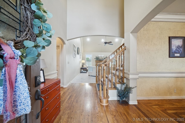 12225 S Glen Ct, Jenks, OK 74037 - foyer featuring arched walkways, a ceiling fan, stairway, a towering ceiling, and wood finished floors
