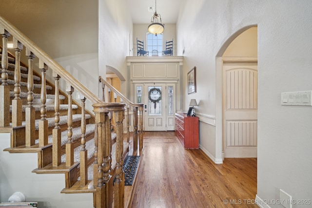 12225 S Glen Ct, Jenks, OK 74037 - foyer featuring arched walkways, wood finished floors, a high ceiling, and stairway