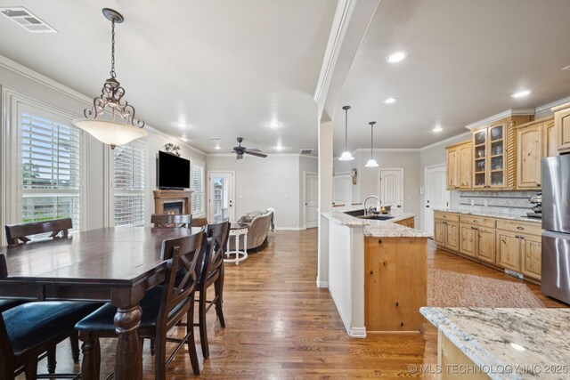 12225 S Glen Ct, Jenks, OK 74037 - kitchen featuring crown molding, freestanding refrigerator, backsplash, light wood-style flooring, and glass insert cabinets