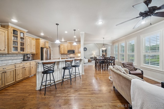 12225 S Glen Ct, Jenks, OK 74037 - kitchen featuring appliances with stainless steel finishes, ornamental molding, a breakfast bar, glass insert cabinets, and recessed lighting