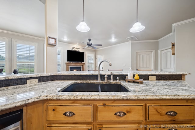 12225 S Glen Ct, Jenks, OK 74037 - kitchen with wine cooler, light stone countertops, crown molding, ceiling fan, and brown cabinetry
