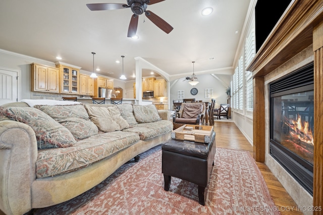 12225 S Glen Ct, Jenks, OK 74037 - living area featuring crown molding, light wood-style floors, a ceiling fan, arched walkways, and recessed lighting