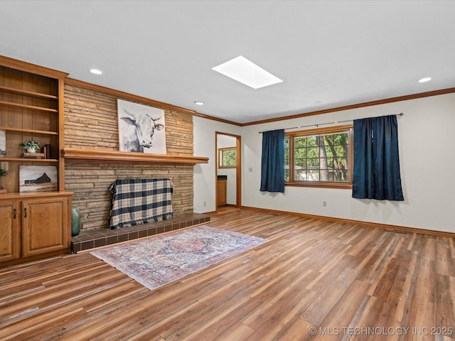 3321 Woodland Rd, Bartlesville, OK 74006 - living room with a skylight, ornamental molding, wood finished floors, recessed lighting, and a tile fireplace