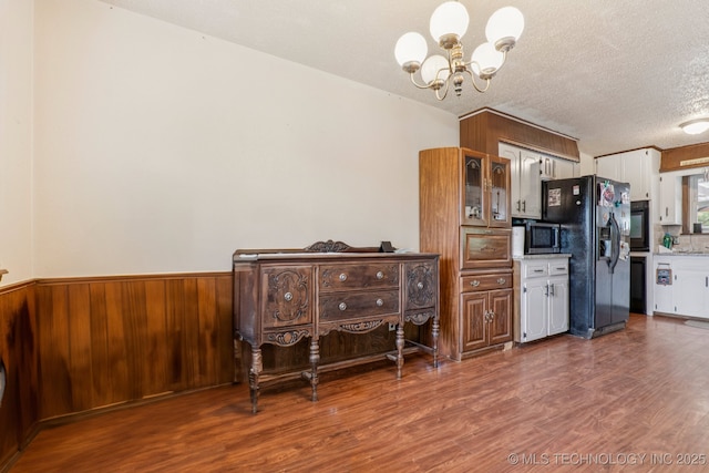 13201 W 86th St S, Sapulpa, OK 74066 - kitchen featuring black appliances, a chandelier, wood finished floors, white cabinets, and a textured ceiling