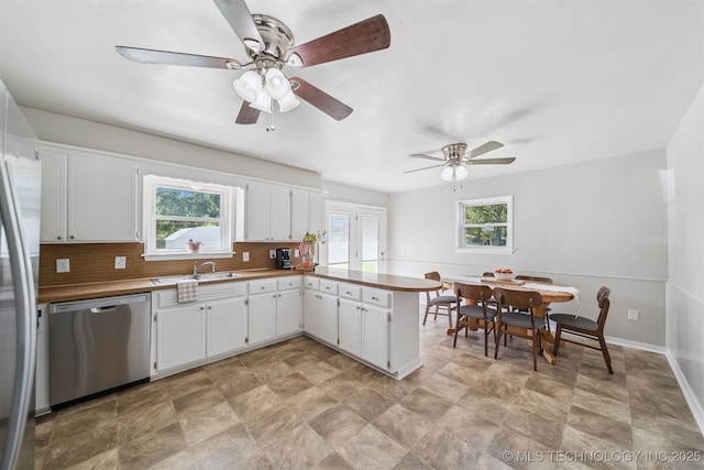1377 S Wortman Ave, Claremore, OK 74017 - kitchen featuring dishwasher, plenty of natural light, a ceiling fan, and tasteful backsplash