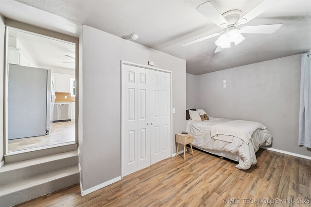 1377 S Wortman Ave, Claremore, OK 74017 - bedroom featuring freestanding refrigerator, wood finished floors, a closet, and a ceiling fan