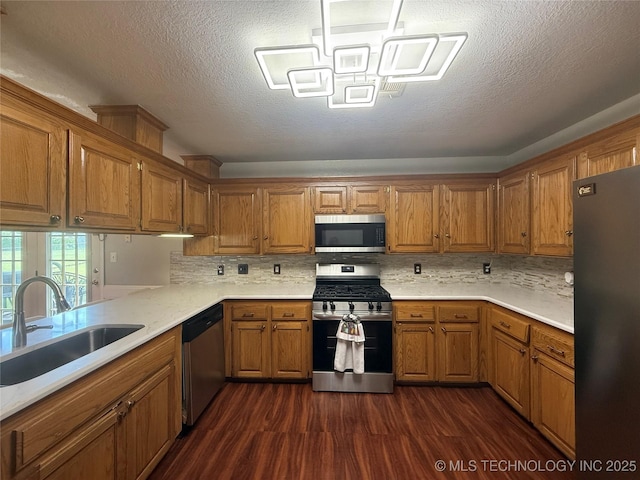 4001 Chaucer, Muskogee, OK 74403 - kitchen with appliances with stainless steel finishes, brown cabinetry, dark wood-style flooring, light countertops, and tasteful backsplash