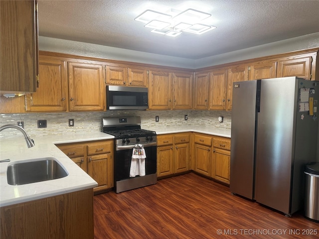 4001 Chaucer, Muskogee, OK 74403 - kitchen with appliances with stainless steel finishes, brown cabinetry, tasteful backsplash, and dark wood finished floors