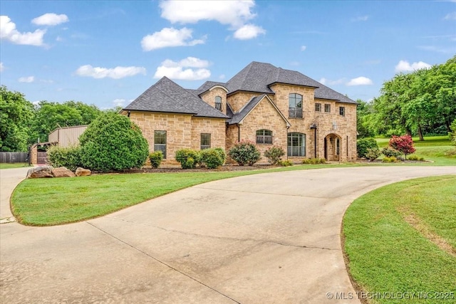 3892 Folsom Rd, Durant, OK 74701 - french country inspired facade featuring stone siding, a front yard, and curved driveway