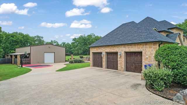 3892 Folsom Rd, Durant, OK 74701 - view of home's exterior featuring a detached garage, stone siding, roof with shingles, and a lawn