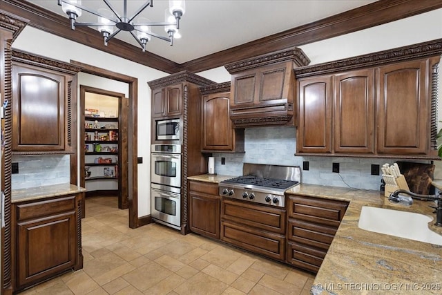 3892 Folsom Rd, Durant, OK 74701 - kitchen featuring stainless steel appliances, tasteful backsplash, a chandelier, crown molding, and hanging light fixtures