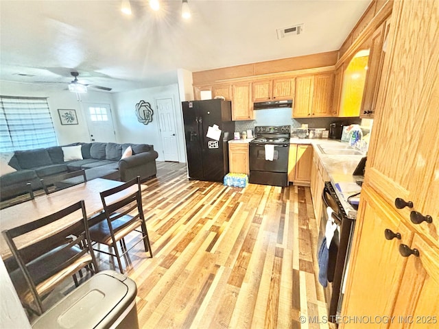 1105 NW 9th St, Stigler, OK 74462 - kitchen with black appliances, light brown cabinets, open floor plan, light countertops, and ceiling fan
