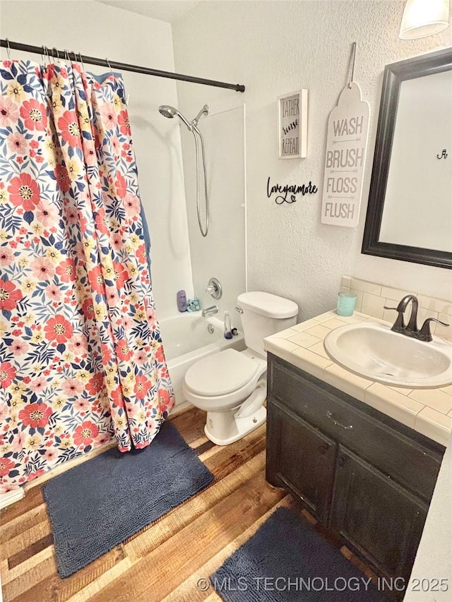 1105 NW 9th St, Stigler, OK 74462 - full bathroom with wood finished floors, vanity, a textured wall, and shower / bath combination with curtain