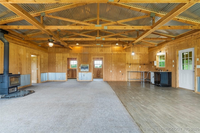 17652 S Hickory St, Sapulpa, OK 74066 - misc room with heating unit, a wood stove, wooden walls, healthy amount of natural light, and a ceiling fan