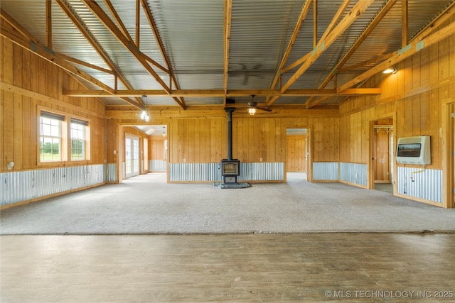 17652 S Hickory St, Sapulpa, OK 74066 - unfurnished living room with heating unit, a wood stove, high vaulted ceiling, wooden walls, and carpet floors