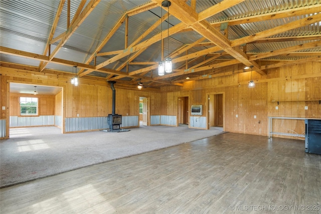 17652 S Hickory St, Sapulpa, OK 74066 - miscellaneous room with a wood stove, high vaulted ceiling, wooden walls, heating unit, and wood finished floors