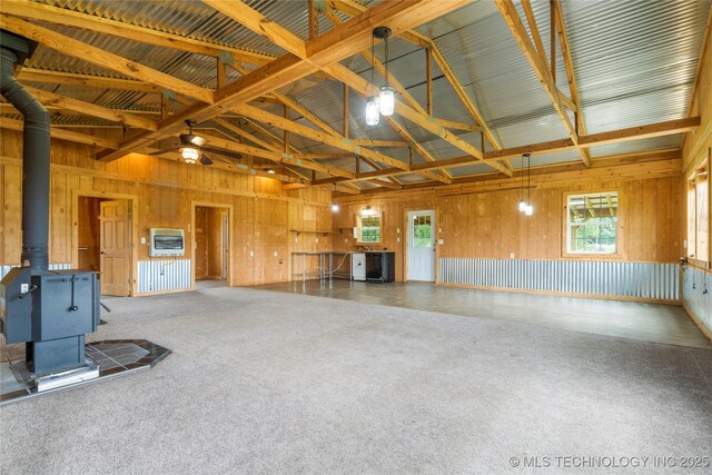 17652 S Hickory St, Sapulpa, OK 74066 - misc room with a wood stove, heating unit, high vaulted ceiling, carpet flooring, and wood walls