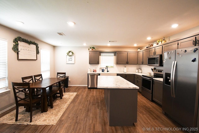 401 N Ash St, Sallisaw, OK 74955 - kitchen with stainless steel appliances, a kitchen island, dark wood finished floors, recessed lighting, and light stone countertops