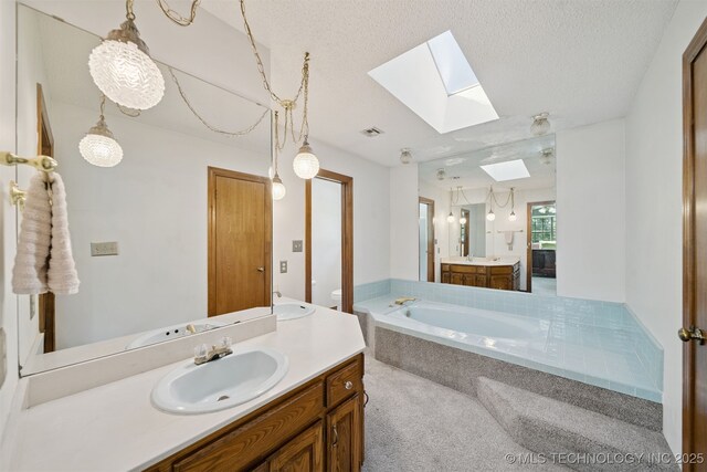19585 Cottrell Dr, Claremore, OK 74019 - full bathroom with a skylight, vanity, a garden tub, and a textured ceiling