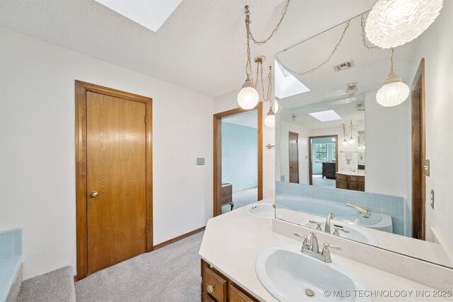 19585 Cottrell Dr, Claremore, OK 74019 - bathroom featuring a skylight, vanity, and a bath