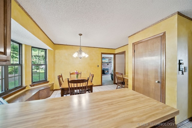 19585 Cottrell Dr, Claremore, OK 74019 - dining space with light tile patterned floors, a textured ceiling, ornamental molding, and a chandelier