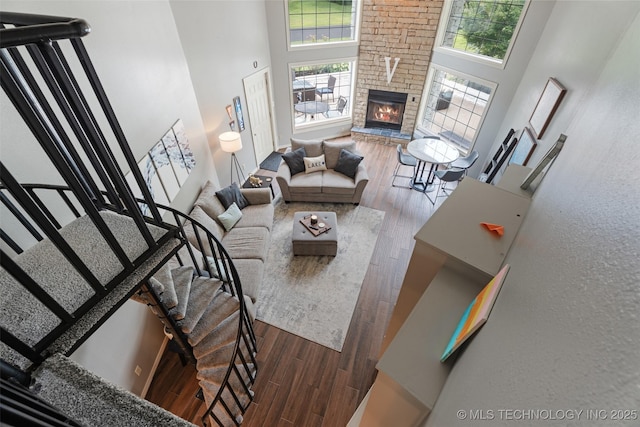 56901 E Walnut, Monkey Island, OK 74331 - living area featuring a towering ceiling, wood finished floors, stairway, and a stone fireplace