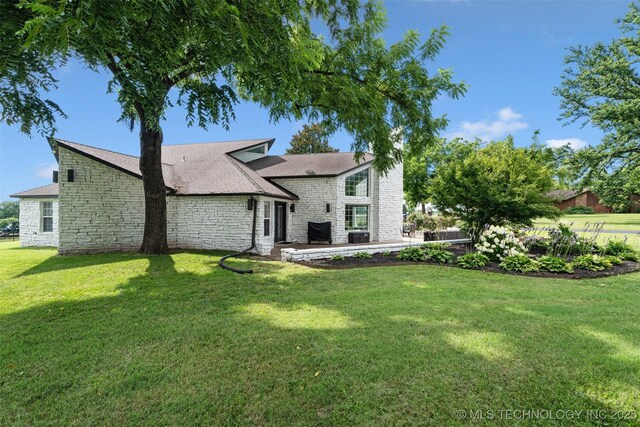 56901 E Walnut, Monkey Island, OK 74331 - back of property with stone siding, a patio, a yard, and roof with shingles