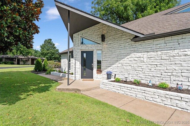 56901 E Walnut, Monkey Island, OK 74331 - view of exterior entry featuring a yard, stone siding, and roof with shingles
