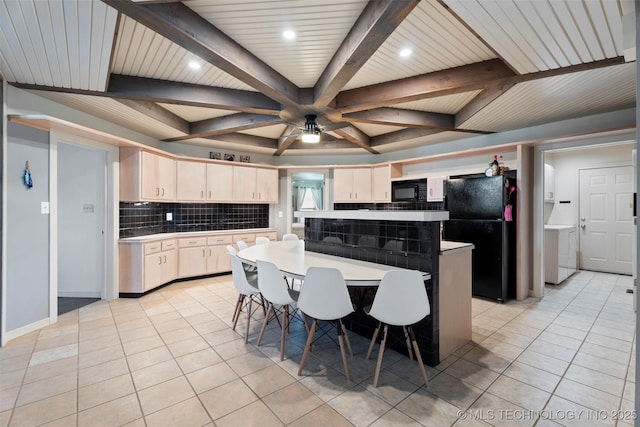 56901 E Walnut, Monkey Island, OK 74331 - kitchen with black appliances, decorative backsplash, light countertops, washer / clothes dryer, and light tile patterned flooring