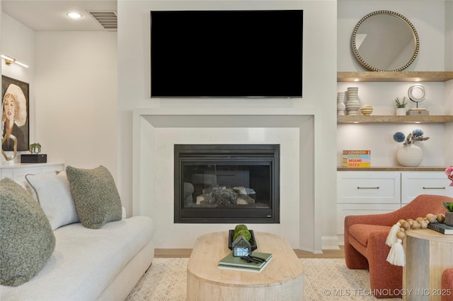 7221 E Norman St, Broken Arrow, OK 74014 - living area featuring a glass covered fireplace, wood finished floors, and recessed lighting