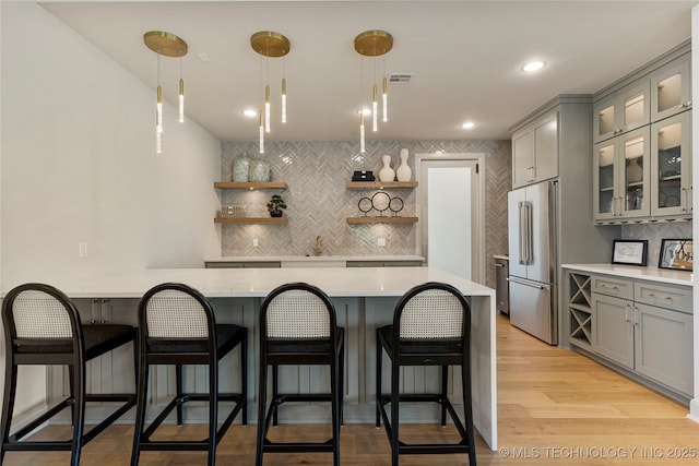 7221 E Norman St, Broken Arrow, OK 74014 - kitchen with high quality fridge, open shelves, gray cabinets, a peninsula, and tasteful backsplash