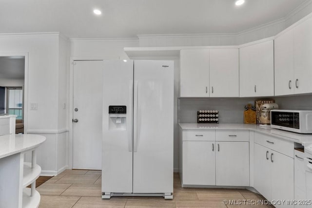 4331 E 28th St, Tulsa, OK 74114 - kitchen featuring white appliances, ornamental molding, white cabinetry, light wood-style floors, and recessed lighting