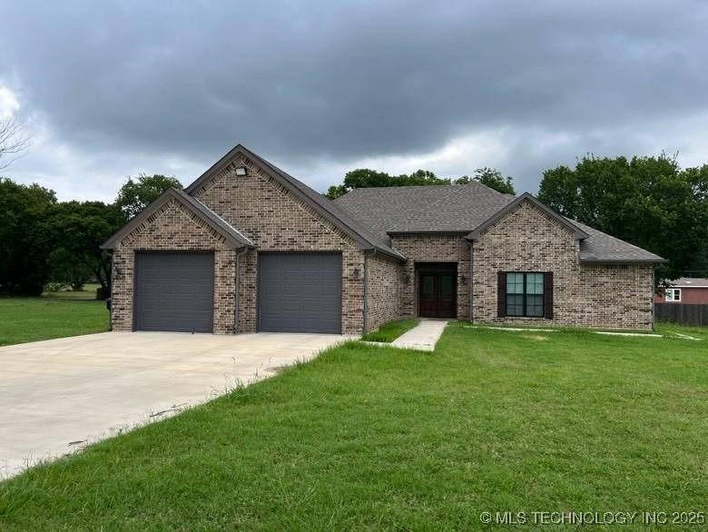 408 S Donehoo, Kingston, OK 73439 - view of front of property with an attached garage, a front yard, french doors, and concrete driveway