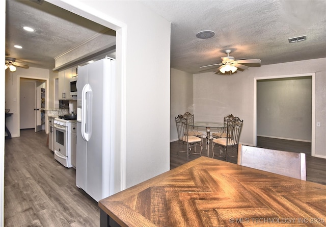 11003 E 27th St, Tulsa, OK 74129 - kitchen featuring ceiling fan, white appliances, a textured ceiling, and wood finished floors