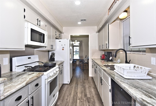 11003 E 27th St, Tulsa, OK 74129 - kitchen featuring white appliances, decorative backsplash, wood finished floors, recessed lighting, and light stone counters