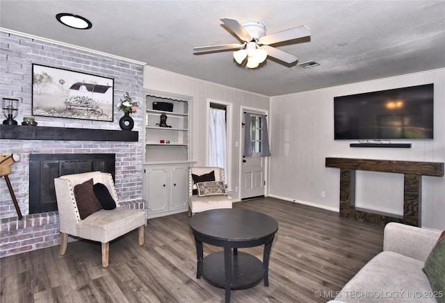 11003 E 27th St, Tulsa, OK 74129 - living room featuring a brick fireplace, ornamental molding, wood finished floors, a ceiling fan, and a textured ceiling
