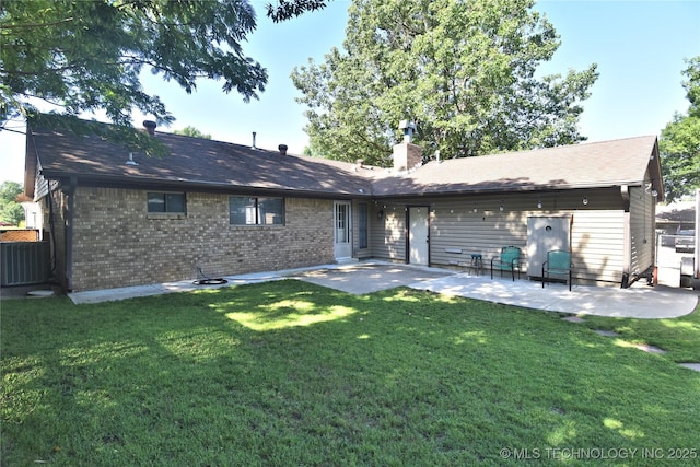 11003 E 27th St, Tulsa, OK 74129 - back of property featuring a patio, a chimney, and brick siding