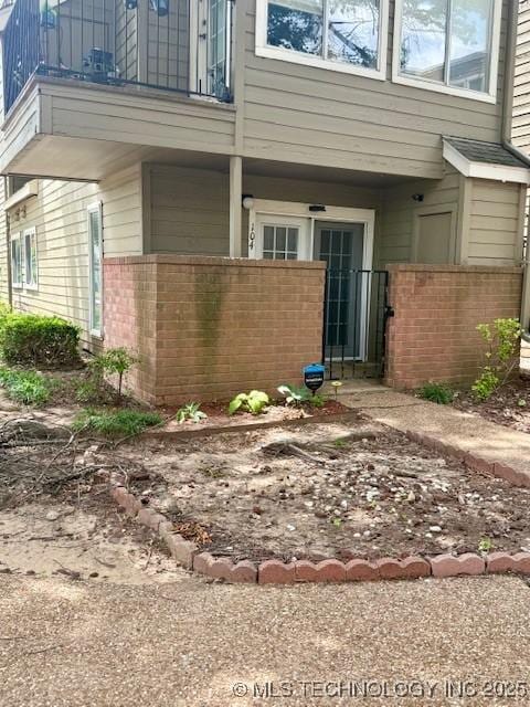 1730 E 67th St Unit K104, Tulsa, OK 74136 - view of exterior entry featuring brick siding and a balcony