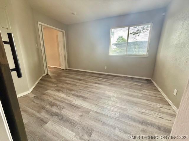 1730 E 67th St Unit K104, Tulsa, OK 74136 - unfurnished room with wood finished floors and baseboards