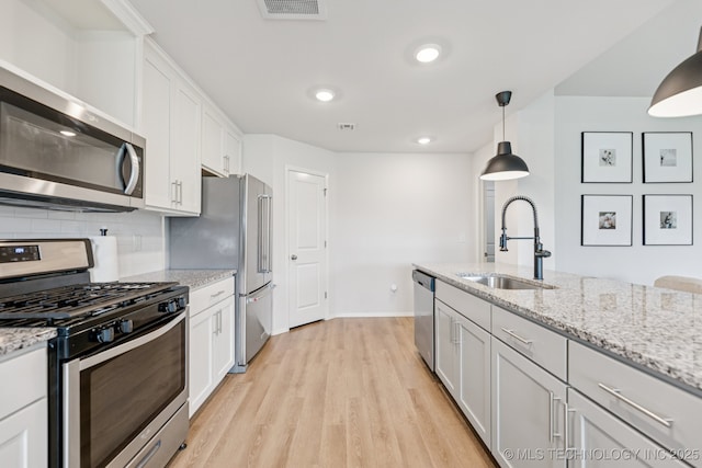 9423 E 132nd Pl S, Bixby, OK 74008 - kitchen with appliances with stainless steel finishes, light wood-style floors, decorative backsplash, decorative light fixtures, and white cabinetry