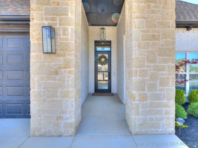 13642 S 21st Pl E, Bixby, OK 74008 - view of exterior entry with roof with shingles, a garage, and brick siding