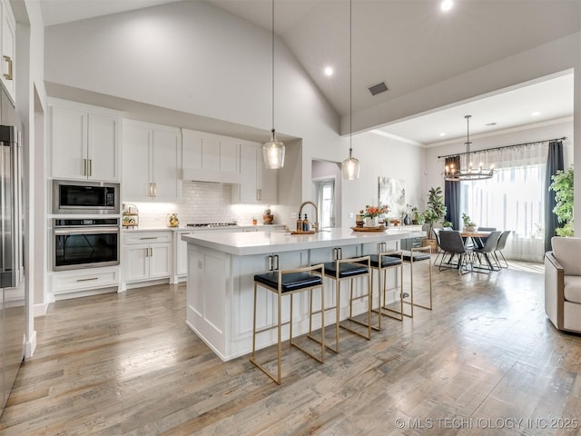 13642 S 21st Pl E, Bixby, OK 74008 - kitchen with appliances with stainless steel finishes, light countertops, recessed lighting, a breakfast bar, and white cabinets