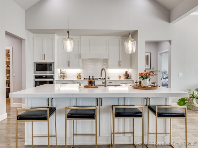 13642 S 21st Pl E, Bixby, OK 74008 - kitchen featuring stainless steel oven, built in microwave, tasteful backsplash, white cabinetry, and high vaulted ceiling