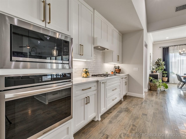 13642 S 21st Pl E, Bixby, OK 74008 - kitchen featuring stainless steel appliances, backsplash, light countertops, white cabinetry, and custom exhaust hood