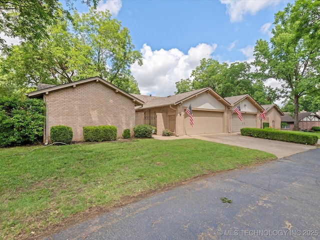 1525 Pecan Pl, Bartlesville, OK 74003 - view of front facade featuring a garage, brick siding, a front yard, and driveway